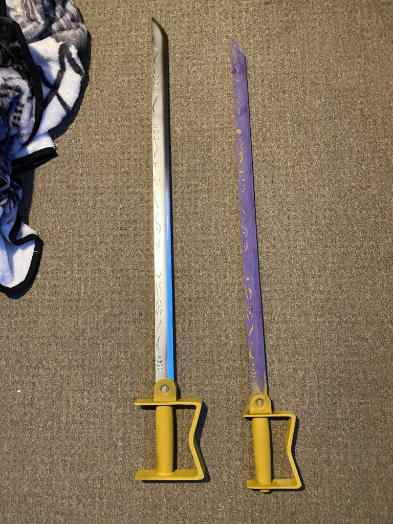 Prototype one and two of General Armstrong's sword. One, silver blade yellow handle. Two, purple unpainted blade, yellow handle.