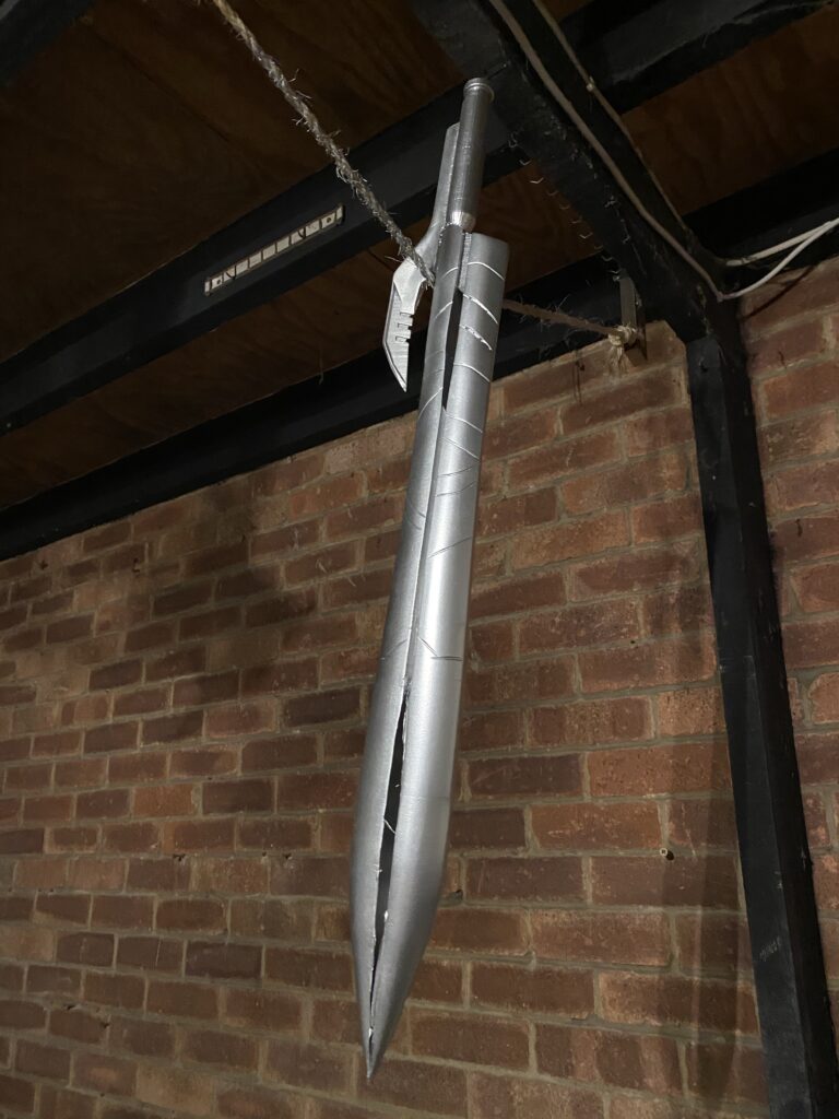 Chrome painted sword dangling from the roof post painting.