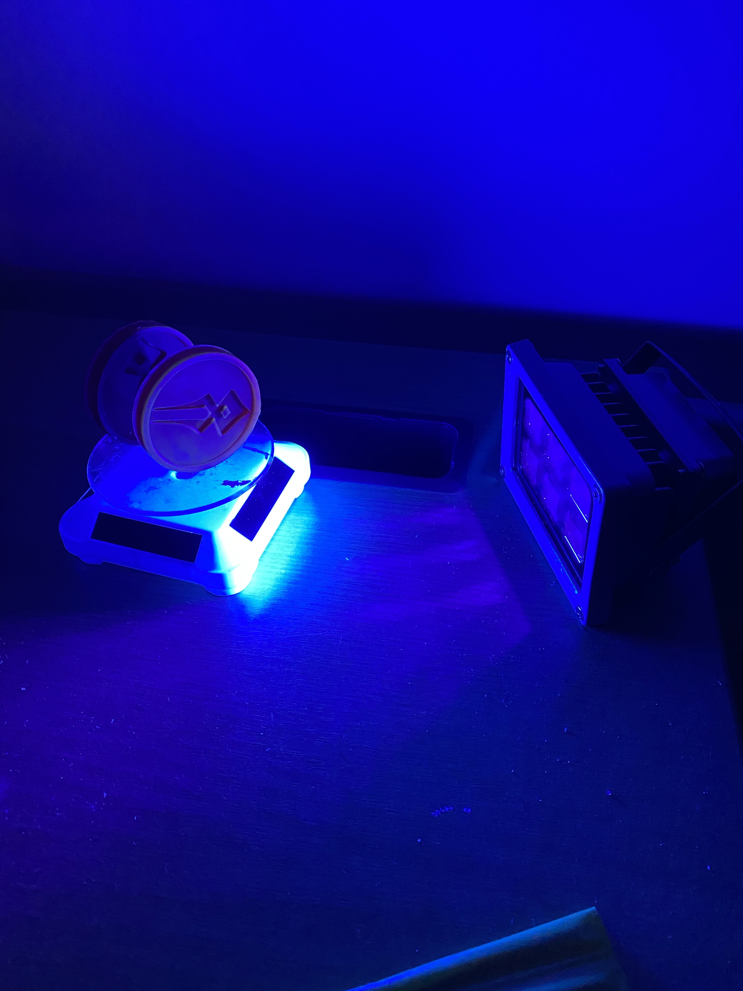 Two coins next to a UV lamp.