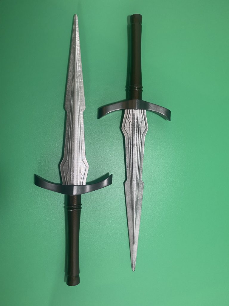 Two finished daggers in parallel on a green background.