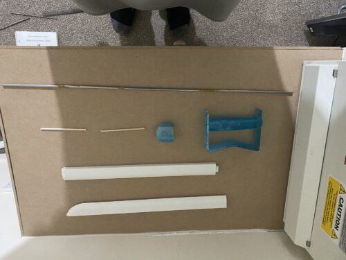 All 3d printed parts of King Bradley's sword laid out in no particular order, with the support rods included.