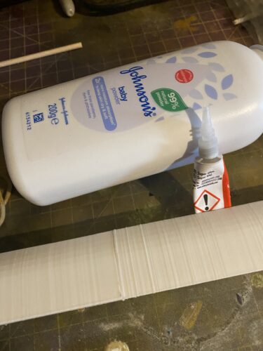 Super glue and talcom powder (to fill in the seems) next to the two blade parts.