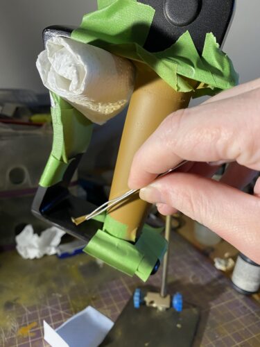 Frog tape being removed from the handle, which is brown and black.,