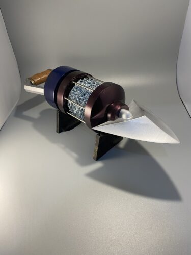 The finished product, one OOT longshot cosplay prop, on a stand with a grey background