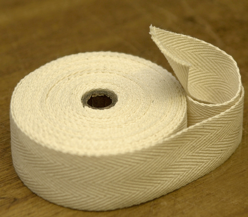 A white roll of cloth tape on a wooden surface.