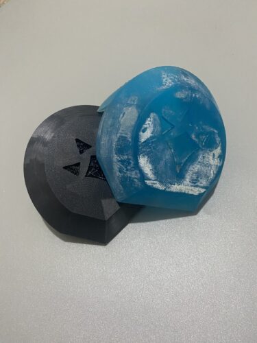 Two Goron Crests, one FDM printed, the other SLA. Black and clear blue colours respectively.