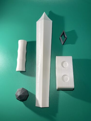 All printed parts of the Raw Build Kit for the Kokiri Sword from Zelda Majora's Mask, printed in grey and white PLA on a green background.