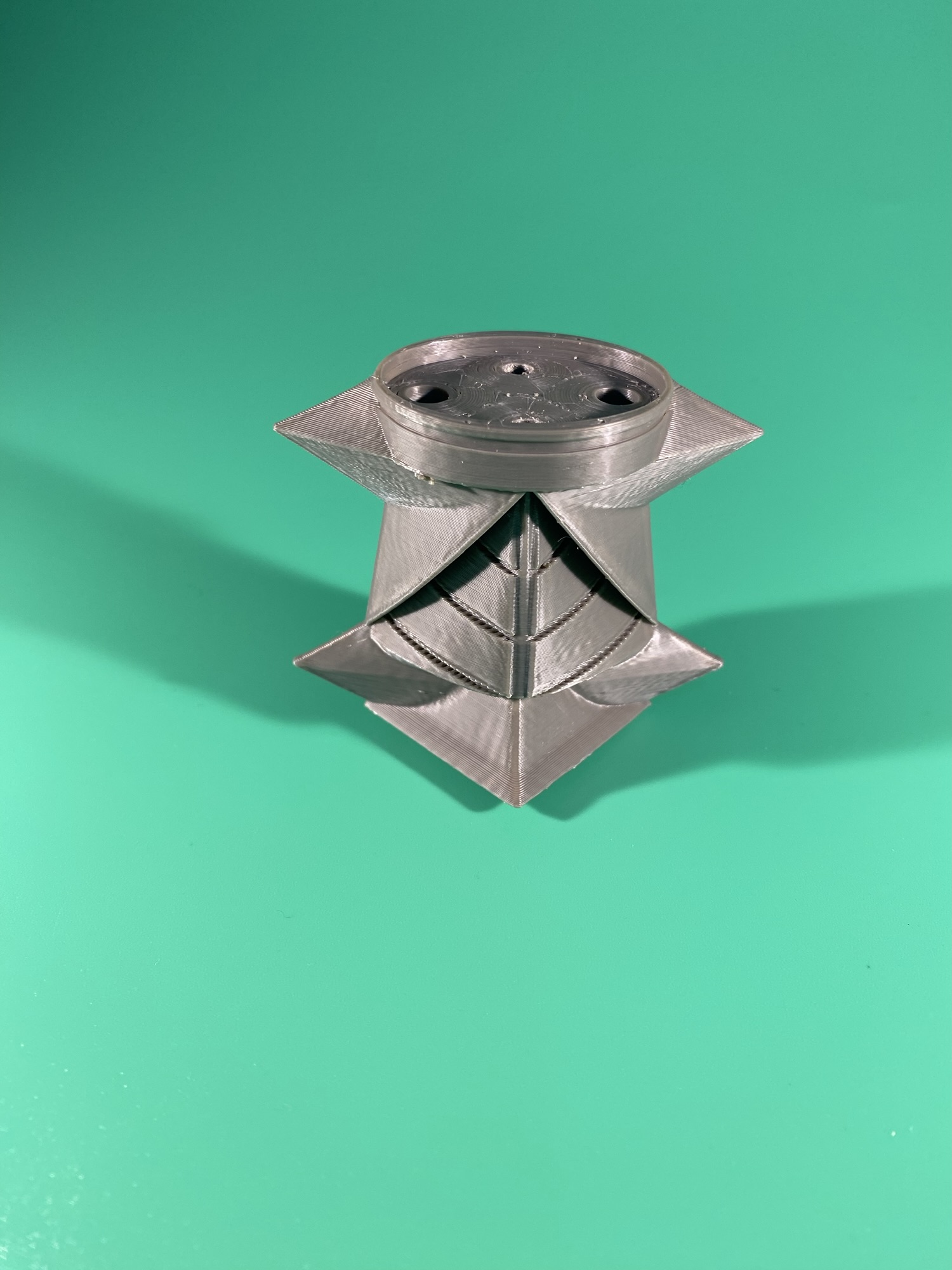 The pommel. Part of the Raw Build Kit for the Razor Sword from Zelda Majora's Mask, printed in grey PLA on a green background.